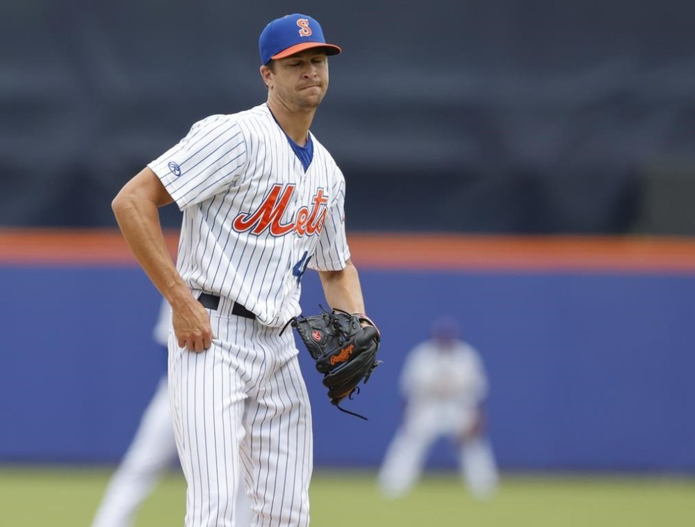 New York Mets' Jacob deGrom reacts after giving up a home run while pitching for triple-A Syracuse against Omaha in what could be his last minor league rehab outing before rejoining New York's rotation, in Syracuse, N.Y., Wednesday, July 27, 2022. (Scott Schild/The Post-Standard via AP)