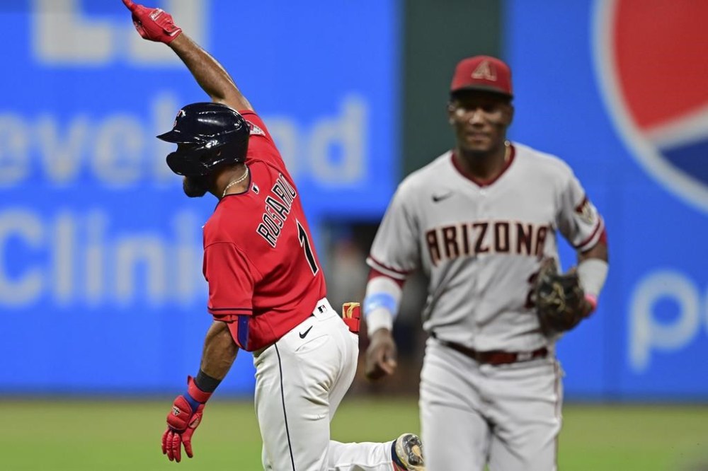 Cleveland Guardians' Amed Rosario, left, celebrates after hitting an RBI-single during the 10th inning of a baseball game against the Arizona Diamondbacks, Monday, Aug. 1, 2022, in Cleveland. (AP Photo/David Dermer)
