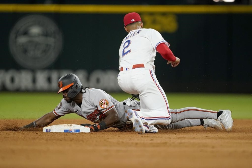 Baltimore Orioles' Jorge Mateo steals second ahead of the attempted tag by Texas Rangers shortstop Marcus Semien (2) in the fifth inning of a baseball game, Monday, Aug. 1, 2022, in Arlington, Texas. (AP Photo/Tony Gutierrez)