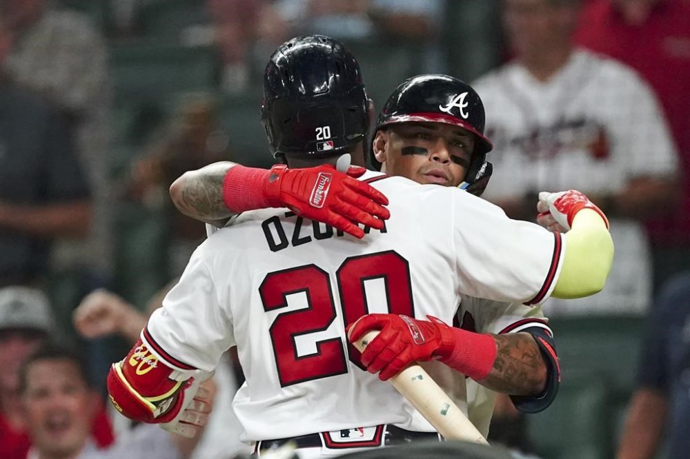 Atlanta Braves' Marcell Ozuna (20) is greeted at home plate by Orlando Arcia (11) after hitting a home run in the seventh inning of a baseball game against the Philadelphia Phillies Tuesday, Aug. 2, 2022, in Atlanta. (AP Photo/John Bazemore)