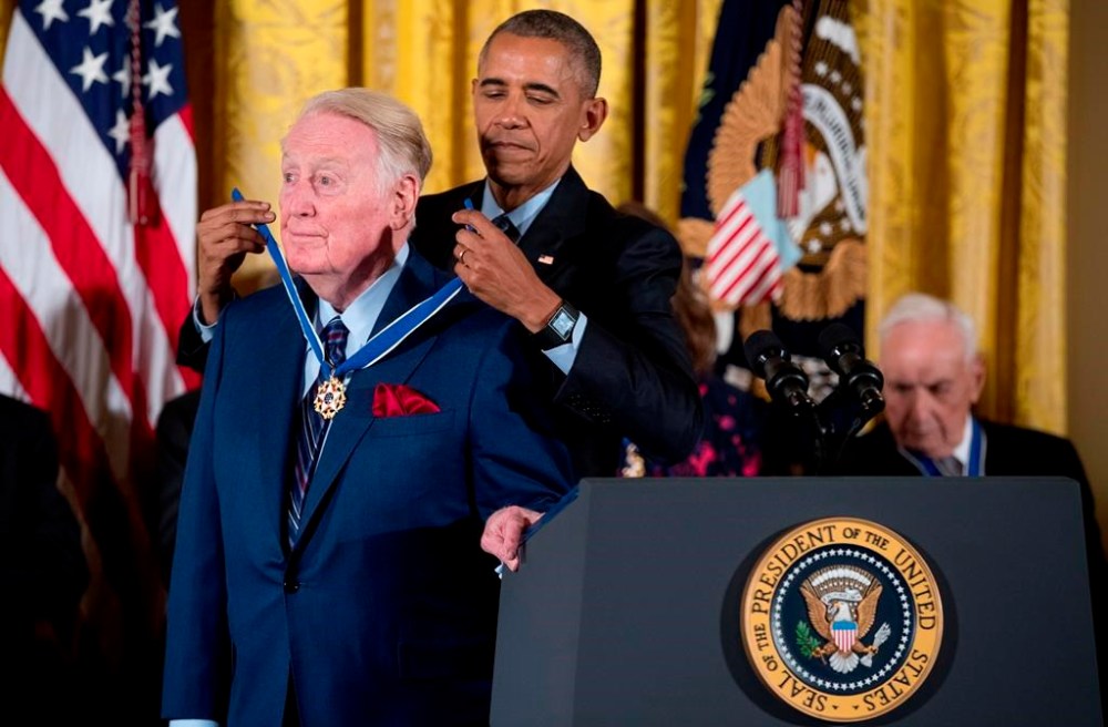 FILE - President Barack Obama presents the Presidential Medal of Freedom to former Los Angeles Dodgers broadcaster Vin Scully in the East Room of the White House in Washington on Nov. 22, 2016. Scully, whose dulcet tones provided the soundtrack of summer while entertaining and informing Dodgers fans in Brooklyn and Los Angeles for 67 years, died Tuesday night, Aug. 2, 2022, the team said. He was 94. (AP Photo/Andrew Harnik, File)