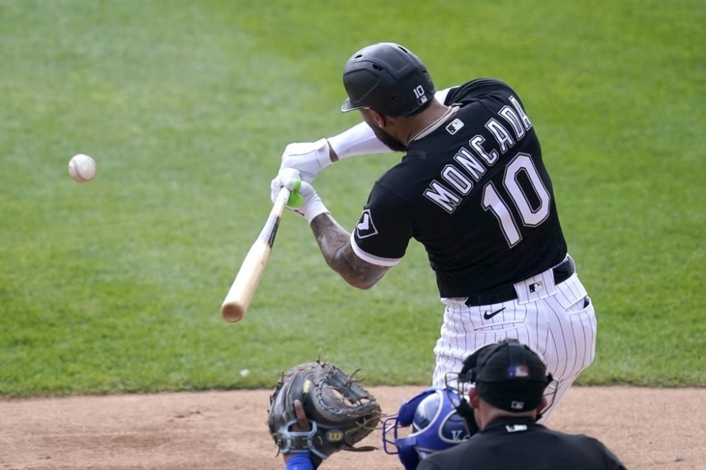 Chicago White Sox's Yoan Moncada swings into an RBI single off Kansas City Royals starting pitcher Brady Singer during the first inning of a baseball game Wednesday, Aug. 3, 2022, in Chicago. (AP Photo/Charles Rex Arbogast)