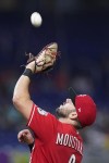 Cincinnati Reds first baseman Mike Moustakas catches ball hit by Miami Marlins' Jesus Aguilar during the eighth inning of a baseball game, Wednesday, Aug. 3, 2022, in Miami. (AP Photo/Wilfredo Lee)