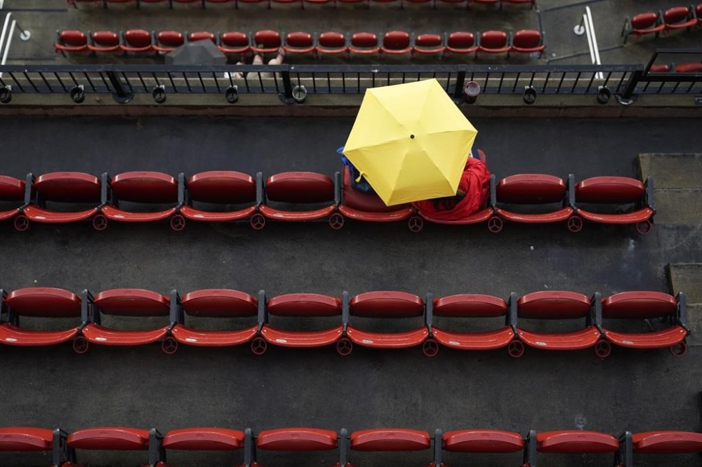 Fans sit in the stands after a scheduled start of a baseball game between the St. Louis Cardinals and the Chicago Cubs Wednesday, Aug. 3, 2022, in St. Louis. The game has been postponed due to weather and the two teams plan to play a doubleheader on Thursday. (AP Photo/Jeff Roberson)