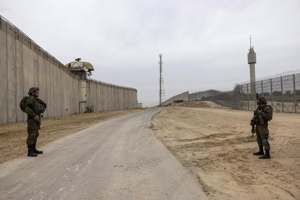FILE - Israeli soldiers secure the site of a ceremony marking the completion of an enhanced security barrier along the Israel-Gaza border, Tuesday, Dec. 7, 2021. The Israeli military says it is sending additional forces to the area around the Gaza Strip as it braces for possible attacks after the arrest of a senior militant in the West Bank this week. Authorities closed roads and other areas around Gaza after a nightly raid Monday, Aug. 1, 2022, in which troops arrested a senior member of the Islamic Jihad militant group in the occupied West Bank town of Jenin. (AP Photo/Tsafrir Abayov, File)