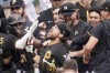 Pittsburgh Pirates' Michael Chavis, center, celebrates with teammates after Milwaukee Brewers reliever Matt Bush threw a wild pitch while he was batting, allowing Bryan Reynolds to score from third, in the 10th inning giving the Pirates the win in the baseball game, Thursday, Aug. 4, 2022, in Pittsburgh. The Pirates won 5-4.(AP Photo/Keith Srakocic)