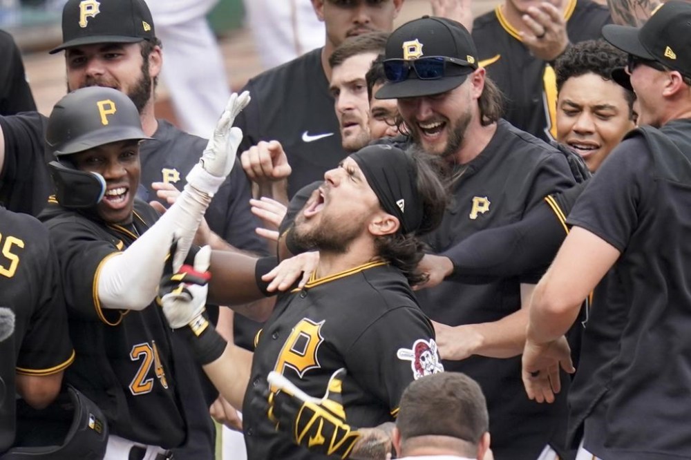 Pittsburgh Pirates' Michael Chavis, center, celebrates with teammates after Milwaukee Brewers reliever Matt Bush threw a wild pitch while he was batting, allowing Bryan Reynolds to score from third, in the 10th inning giving the Pirates the win in the baseball game, Thursday, Aug. 4, 2022, in Pittsburgh. The Pirates won 5-4.(AP Photo/Keith Srakocic)