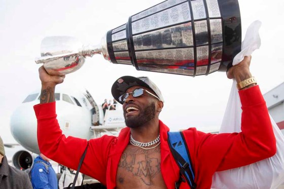 Bombers defensive end Willie Jefferson carries the Grey Cup off the plane after the team landed in Winnipeg in Monday. (Mike Deal / Winnipeg Free Press files)
