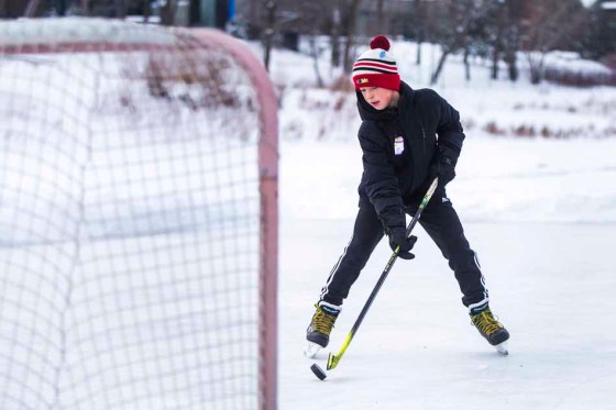 Miles Yoshida, 12, practices shooting pucks on the Assiniboine River on Monday. (Mikaela MacKenzie / Winnipeg Free Press)