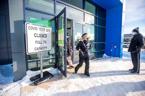 Caine Rudy (left) and Jennifer Franczyk walk out as Jordan Wieler waits to get a rapid test at a COVID-19 testing site Thursday. (Mikaela MacKenzie / Winnipeg Free Press)