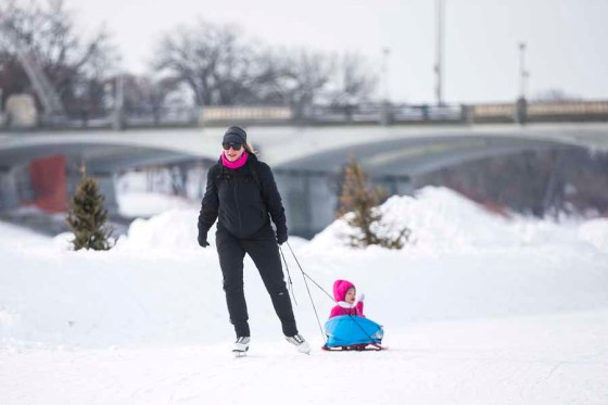 Twila Fillion pulls her daughter, Raphaëlle, 2, on the Nestaweya River Trail on Tuesday. (Mikaela MacKenzie / Winnipeg Free Press)