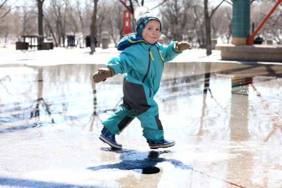 Louis Asselin, 2, splashes in the puddles under the canopy at The Forks on Tuesday. (Ruth Bonneville / Winnipeg Free Press)