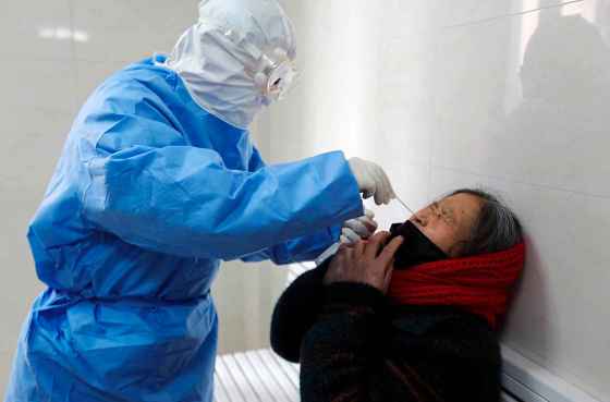 Chinatopix / The Associated PressA doctor takes a swab from a woman to test for the COVID-19 virus at a fever clinic in Yinan county in eastern China's Shandong province Wednesday.