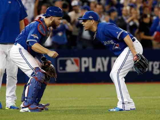 Matt Slocum / The Associated PressToronto Blue Jays relief pitcher Roberto Osuna and catcher Russell Martin celebrates their 11-8 win against the Kansas City Royals in Game 3 of baseball's American League Championship Series on Monday.