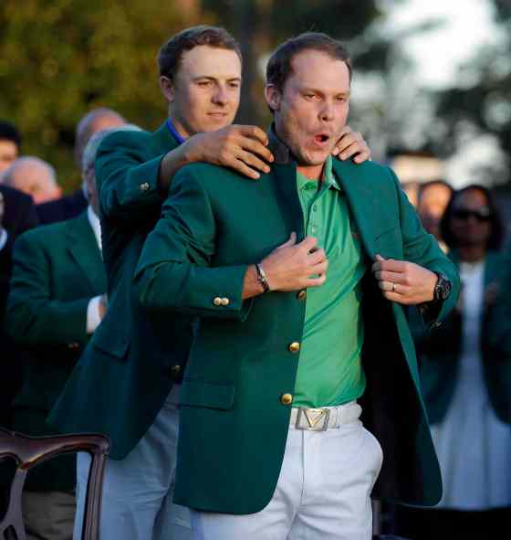 CHRIS CARLSON / THE ASSOCIATED PRESSDefending champion Jordan Spieth, left, helps 2016 Masters champion Danny Willett, of England, put on his green jacket following the final round of the Masters golf tournament Sunday, in Augusta, Ga.