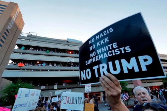 Matt York / The Associated PressPeople protest outside the Phoenix Convention Center, Tuesday, in Phoenix. Protests were held against President Trump as he hosted a rally inside the convention center.
