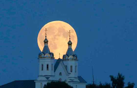 Sergei Grits / The Associated Press FilesA perigee moon, also known as a supermoon, rises above Novogrudok, Belarus, in August. The supermoon happens when moon is full and makes it closest approach to Earth in her orbit; this weekend, it will also coincide with a lunar eclipse.