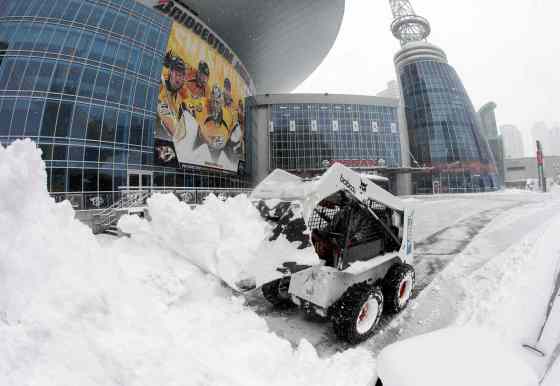 Mark Humphrey / Associated Press filesIn this image taken with a fisheye lens, snow is removed from in front of Bridgestone Arena, Friday in Nashville, Tenn.