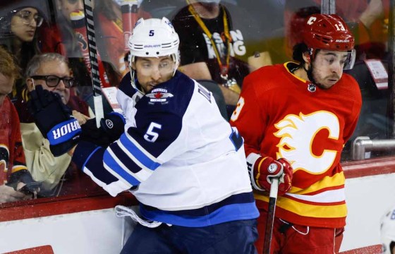 Jets defenceman Brenden Dillon checks Calgary Flames forward Johnny Gaudreau during a game in Calgary in February. (Jeff McIntosh / The Canadian Press files)
