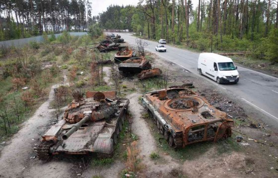 APCars drive past destroyed Russian tanks in the village of Dmytrivka, near Kyiv. (Efrem Lukatsky / The Associated Press files)