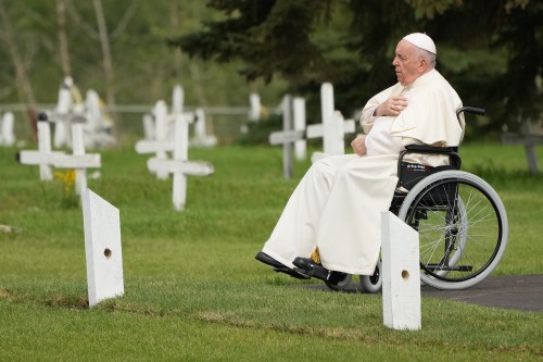Pope Francis prays at a gravesite at the Ermineskin Cree Nation Cemetery in Maskwacis, Alta., during his papal visit across Canada on Monday, July 25, 2022. THE CANADIAN PRESS/Nathan Denette