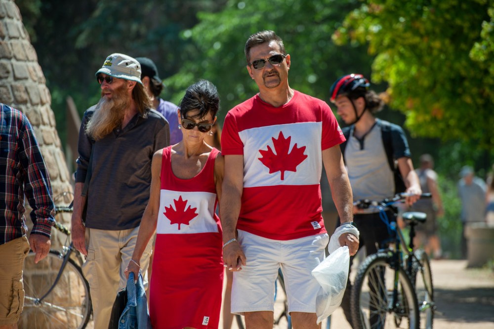 ETHAN CAIRNS / WINNIPEG FREE PRESS
A couple walks dressed in a matching Canada flag outfit at the New Day Ceremony at The Forks in Winnipeg, Manitoba on Friday, July 1, 2022