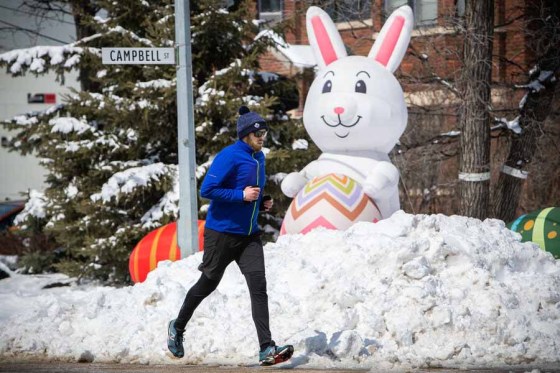 Daniel CrumpA runner on Wellington Crescent passes an inflatable Easter bunny in a front yard on Saturday afternoon. (Daniel Crump / Winnipeg Free Press files)