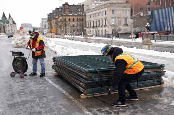 CPCrews remove fencing from in front of the West Block on Parliament Hill on Monday. (Adrian Wyld / The Canadian Press)