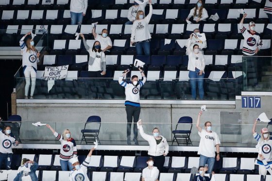 THE CANADIAN PRESSSome of the limited number of fans in the stands at Winnipeg’s downtown arena celebrate a Jets goal during a playoff game in June. (The Canadian Press files)