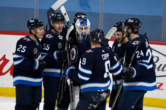 CPWinnipeg Jets players celebrate their win over the Calgary Flames in Winnipeg on Tuesday night. (Fred Greenslade / The Canadian Press)