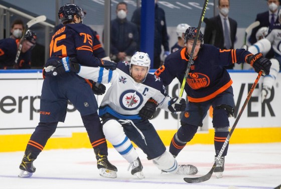 CPOilers players Evan Bouchard and Kyle Turris defend against Winnipeg Jets captain Blake Wheeler in Edmonton on Wednesday night. (Jason Franson / The Canadian Press)