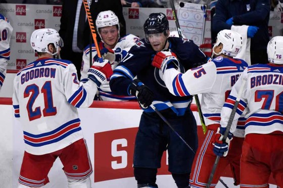 Fred Greenslade / The Canadian PressJets centre Adam Lowry is pushed by two Rangers players in the third period. (Fred Greenslade / The Canadian Press)