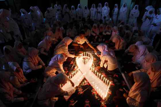 Trisnadi / The Associated PressIndonesian medical students light candles during a vigil commemorating World AIDS Day in Surabaya, East Java, Indonesia, Monday.