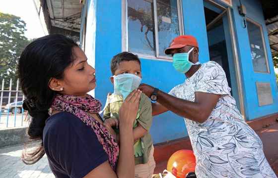 Pradeep Kumar / The Associated PressA man wearing a surgical mask makes a child wear one outside the government general hospital where a student who had been in Wuhan is kept in isolation in Thrissur, Kerala state, India, Thursday.