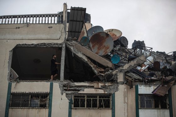 CPA Palestinian searches for survivors under the destroyed rooftop of a residential building at a refugee camp in Gaza. (Khalil Hamra / The Associated Press)