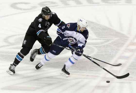 JEFF CHIU / THE ASSOCIATED PRESSWinnipeg Jets center Alexander Burmistrov (6) skates in front of San Jose Sharks defenceman Brenden Dillon (4) during the first period of an NHL hockey game in San Jose, Calif., Thursday.