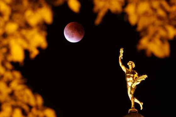 JOHN WOODS / THE CANADIAN PRESSA lunar eclipse on a supermoon appears behind the Golden Boy at the Manitoba Legislature in Winnipeg Sunday,
