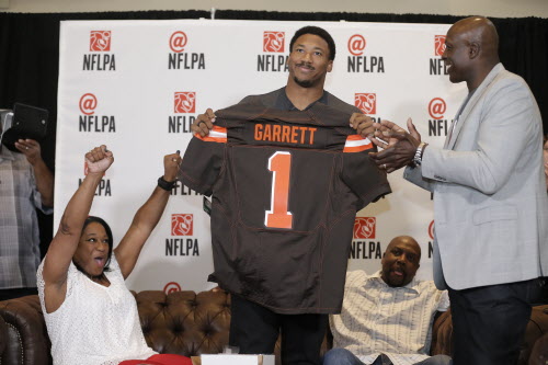 BRANDON WADE / ASSOCIATED PRESS / NFLPAFormer No. 1 overall pick Bruce Smith (right) presents a Cleveland Browns jersey to Myles Garrett while his mother Audrey (left) and father Lawrence look on at the draft party in Arlington, Texas.