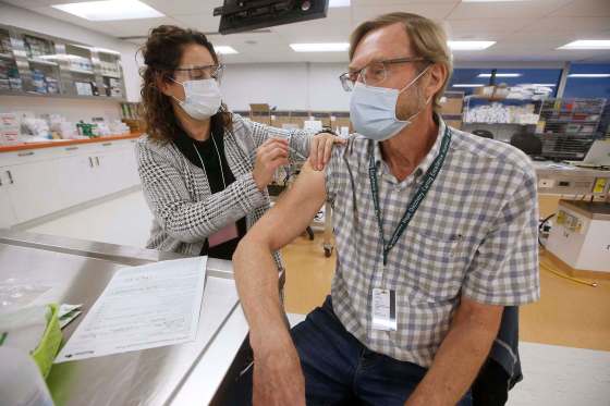 Dr. Brian Penner receives the first COVID-19 inoculation in Manitoba from LoriAnn Laramee, a public health nurse, at Health Sciences Centre on Dec. 16, 2020. (John Woods / The Canadian Press files)