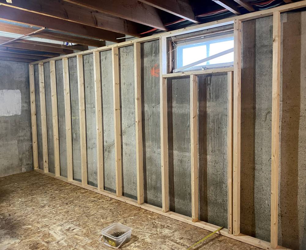 The 2x4 exterior wall frame is set directly atop the sub-floor with air gap technology, an inch from the concrete wall to allow total spray-foam insulation coverage.
