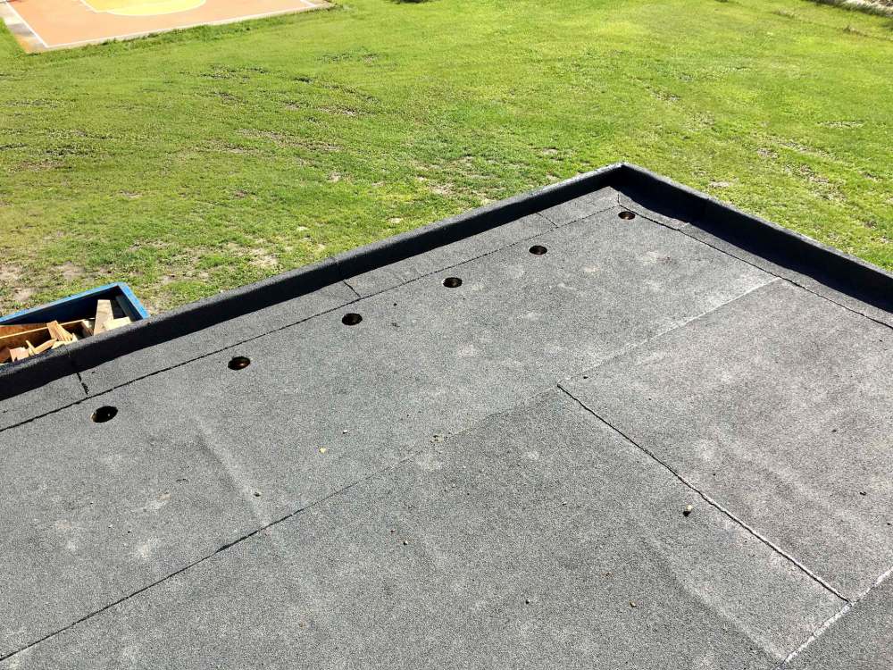 Marc LaBossiere / Winnipeg Free Press
The torch-on roof process is completed, and holes centered in the eventual joists cavities lead to downspouts and to a main gutter.