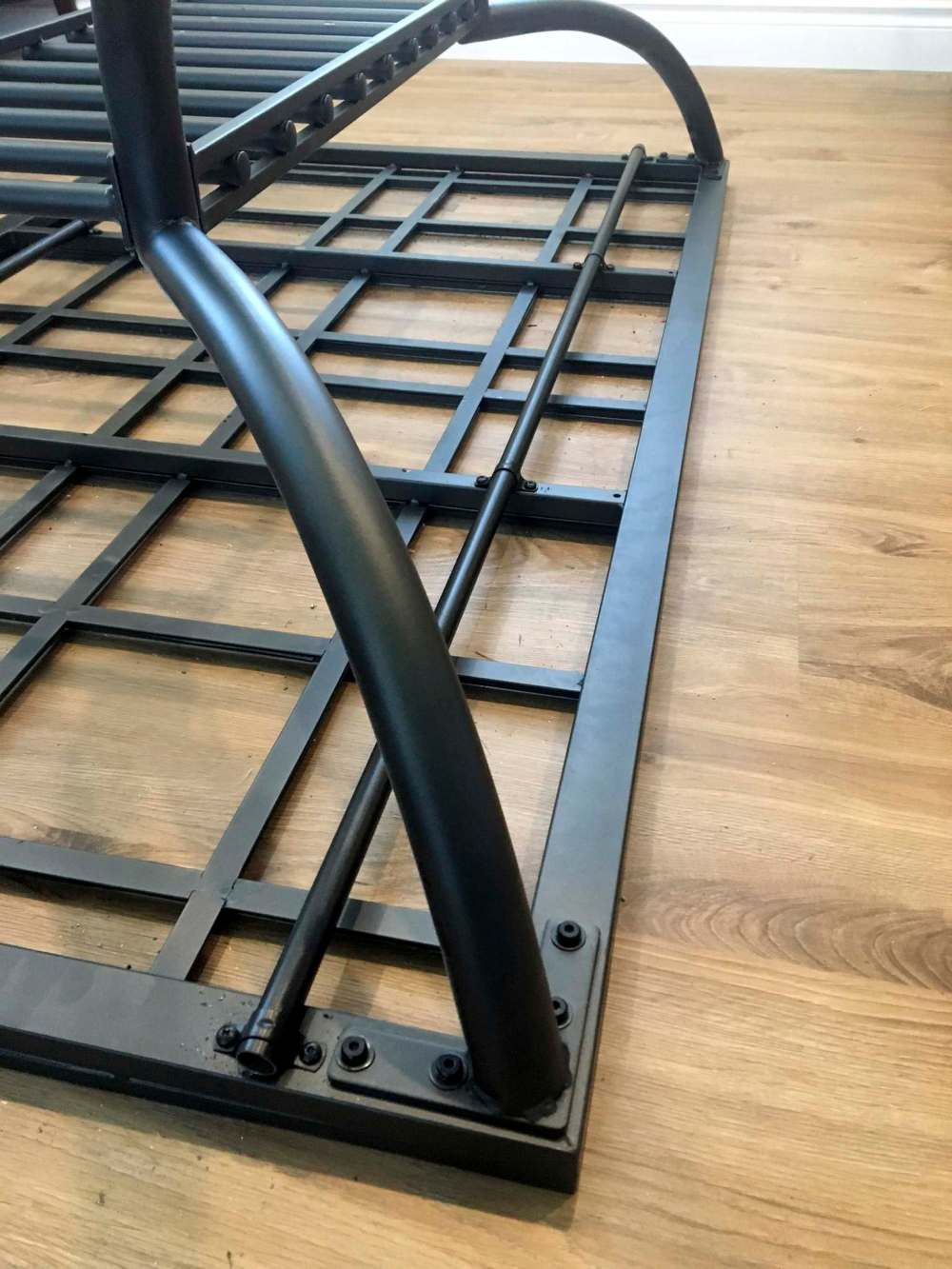 Two table-length metal conduits are fastened to the underside of the existing table, and spray-painted to match, metal dowels fastened to each leaf moves in and out of the conduit, allowing the leaves removable.