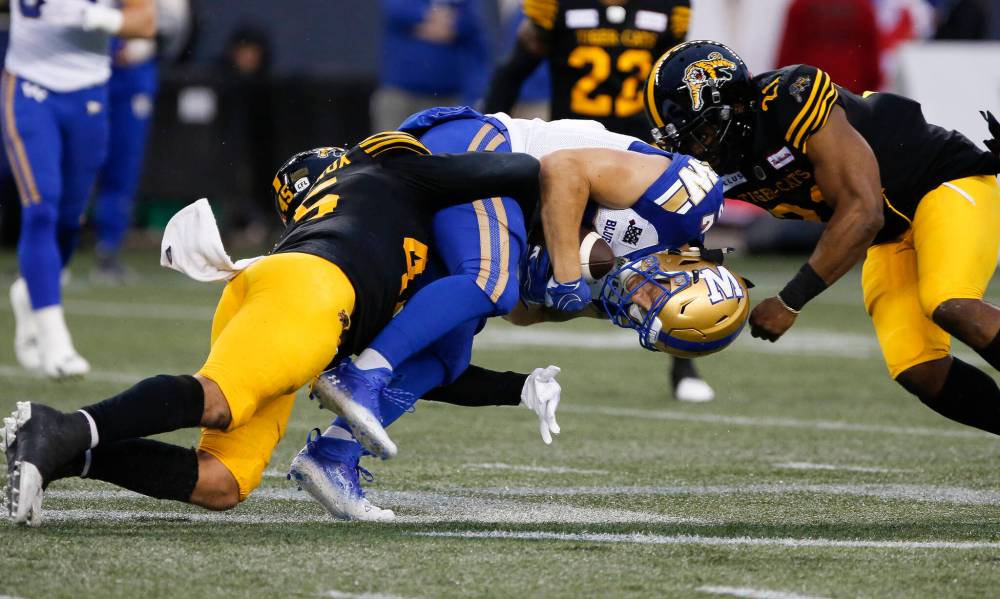 THE CANADIAN PRESS/John Woods
Winnipeg Blue Bombers’ Drew Wolitarsky (82) gets tackled by Hamilton Tiger-Cats’ Jovan Santos-Knox (45) and Simoni Lawrence (21) during the first half.