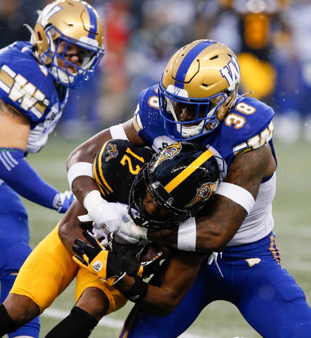 THE CANADIAN PRESS/John Woods
Winnipeg Blue Bombers’ Donald Rutledge (38) tackles Hamilton Tiger-Cats’ Tim White (12) during the first half.