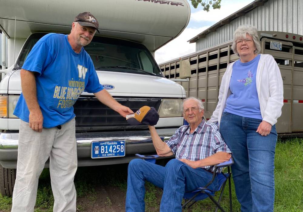 Patty Doerksen photo
Terry Doerksen (left) presents Minnesotans Terry and Bev Hockett with a Winnipeg Blue Bombers cap. Bombers legend Melvin (Fritz) Hanson (a.k.a. ‘the Galloping Ghost’) was from nearby Perham, Minn. Terry Hockett’s father played football for Perham’s rival town.