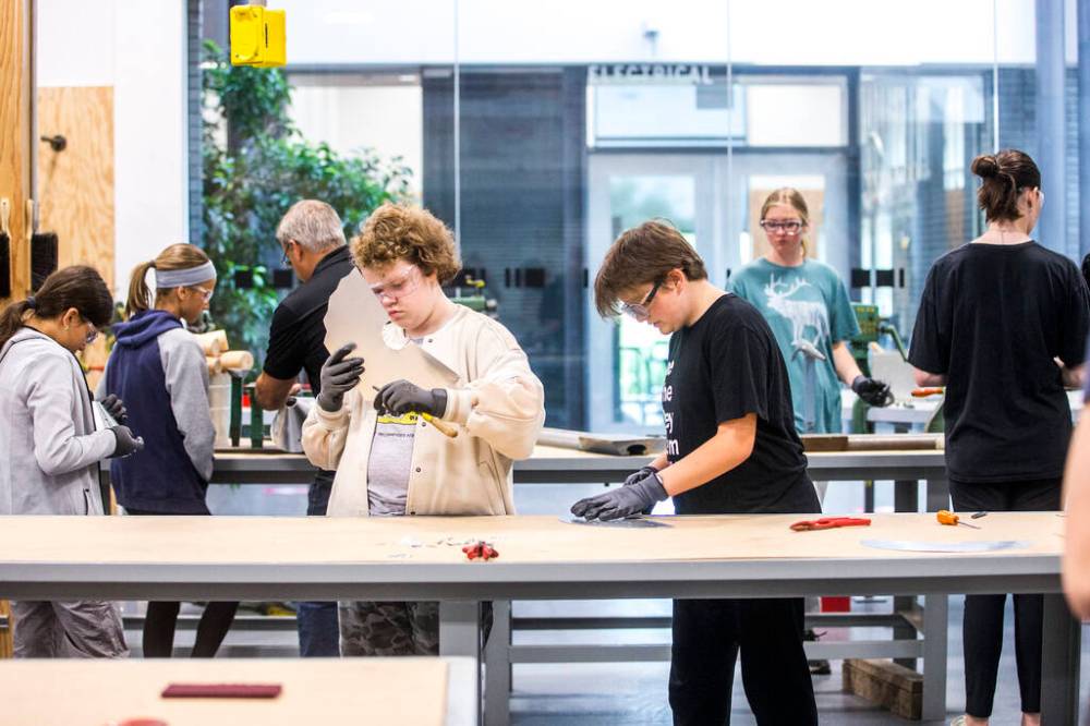 MIKAELA MACKENZIE / WINNIPEG FREE PRESS
Parc Richardson (centre left) and Marisa Zielinski work on metal lampshades at the Girls Exploring Trades and Technology camp at RRC Polytech in Winnipeg.