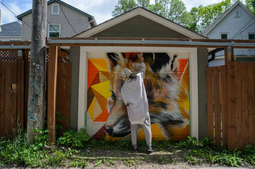 ETHAN CAIRNS / WINNIPEG FREE PRESS
Nereo Zorro’s spray paints his mural of a fox behind 500 Langside St.