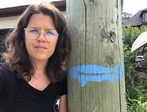 SUPPLIED
Amanda Leighton, of the interchurch council, with a sturgeon stencilled on a hydro pole.