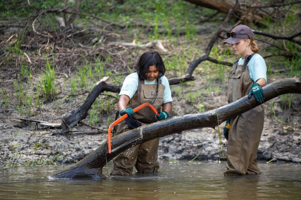 ETHAN CAIRNS / WINNIPEG FREE PRESS
Aided by Abby Rodrigue, Rishtia Rajib cuts a large fallen branch near Happyland Park. ‘Volunteers,’ says SOS board chair Laurie Ringaert, ‘that’s what makes us a great organization.’