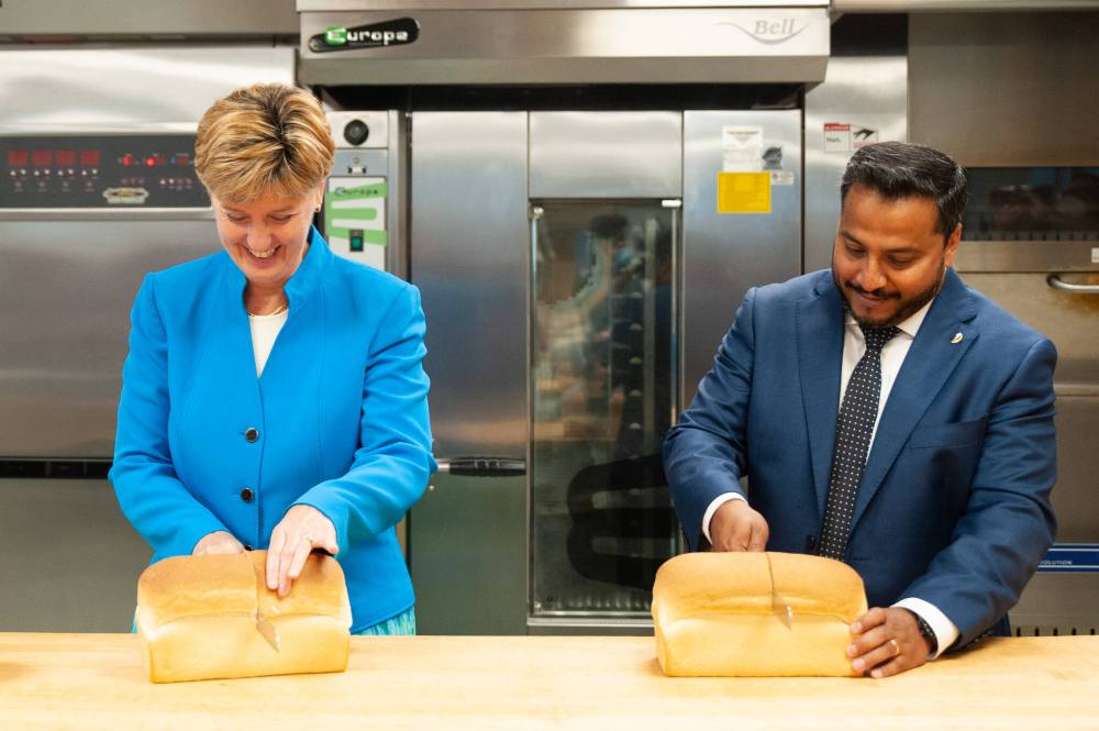 ETHAN CAIRNS / WINNIPEG FREE PRESS
Federal Agri-Food Minister Marie-Claude Bibeau and Cereals Canada CEO Dean Dias slice bread on Tuesday in Winnipeg.